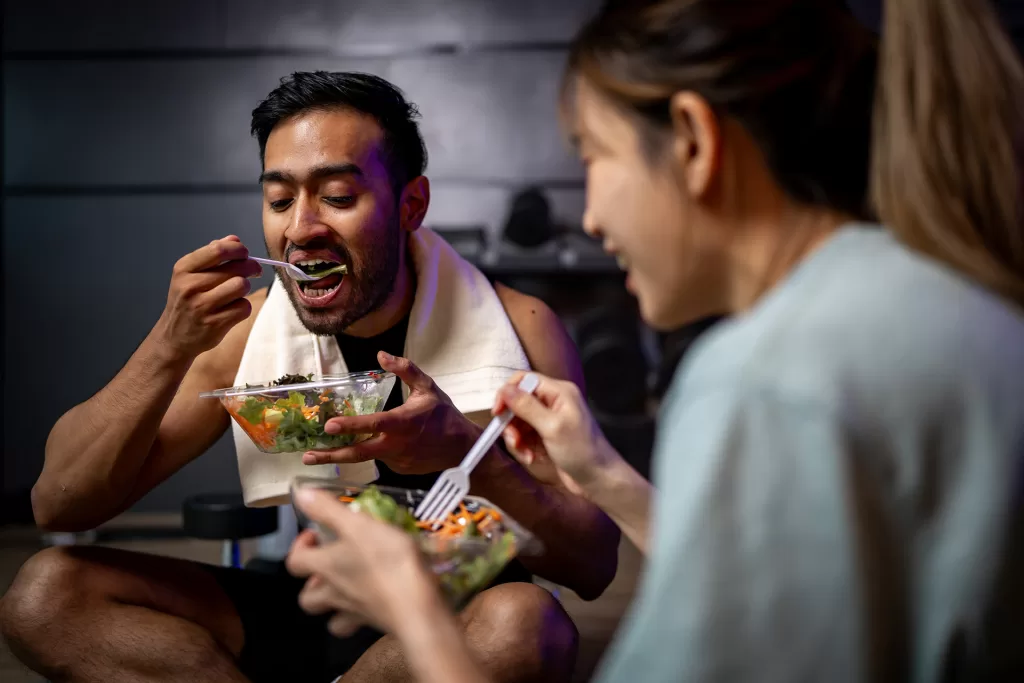 two men and women are eating a vegetable salad tog 2024 09 27 00 30 10 utc