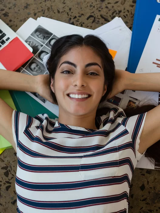 woman relaxing on documents with arms behind head 2023 11 27 05 03 17 utc